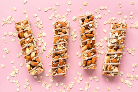 Almond and oat granola protein bars on pink background, top view. Healthy vegan granola barsの写真素材