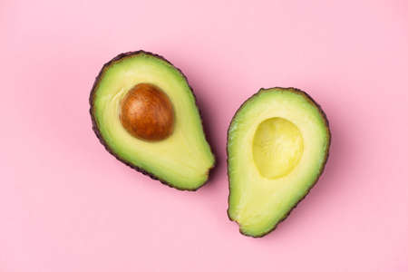 Avocado halves with core on pink background. Minimalist still life backgroundの写真素材