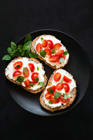 Ricotta Tomato Bruschetta With Basil On Black Background, Top View Copy Space. Italian Appetizer...