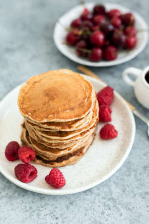 Oat pancakes with berries on plate. Healthy vegan vegetarian pancakes, low calorie pancakes