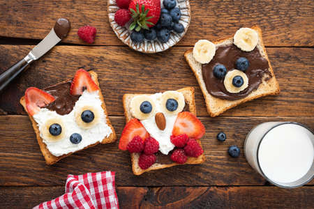 Kids breakfast funny toasts on wooden table.の写真素材