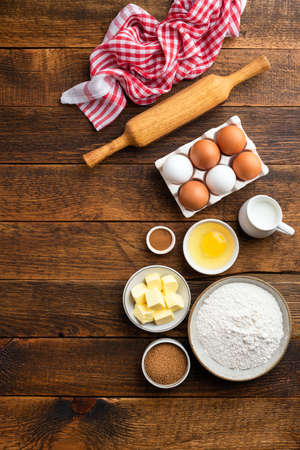 Ingredients for baking pastry, cake, cookies or bread on a wooden table background. Top view, copy space. Home baking conceptの写真素材