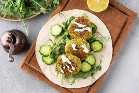 Falafel with sauce on tortilla bread. Healthy homemade falafel tortilla wrap preparation