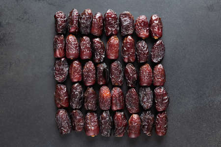 Dry Medjool Dates On Black Slate Background. Group of Dried Date Fruits. Arabic Foodの写真素材