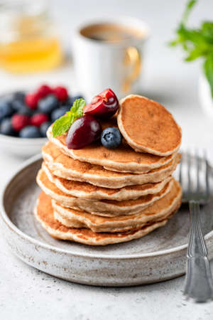 Vegan oat pancakes with berries on plate. Gluten free pancakes stackの写真素材