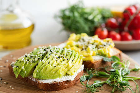 Avocado cream cheese toast with seeds and microgreens. Healthy snack appetizer or breakfast
