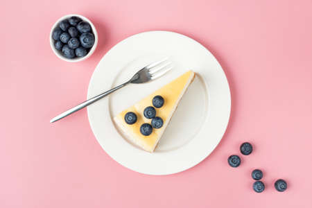 Cheesecake with blueberries on pink background, top view. Slice of cheese cakeの写真素材