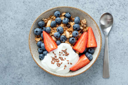 Healthy breakfast granola with berries and greek yogurt. Top view isolated bowl of whole grain cerealsの写真素材