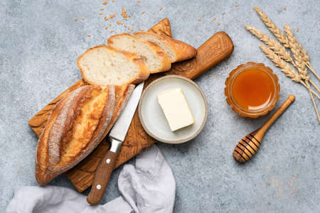Bread, butter and honey still life. Top view. Baguette bread with butter and honey