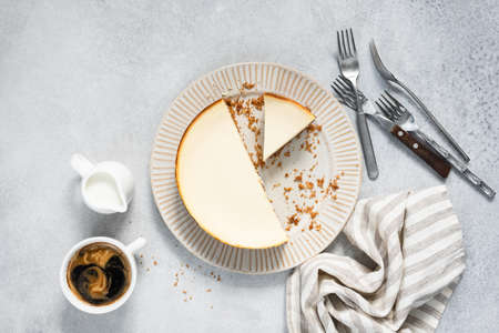 Cheesecake sliced on plate and coffee on a gray concrete background, top view. Tasty cheese cakeの写真素材