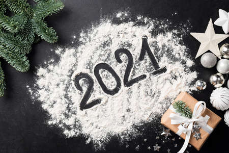 2021 new year symbol written with flour on black concrete background with Christmas, New Year...