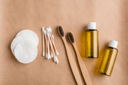 Eco friendly cosmetology and medical cleansing accessories. Cotton pads, bamboo ear sticks, oil essence pots and charcoal toothbrushes on beige backgroundの写真素材