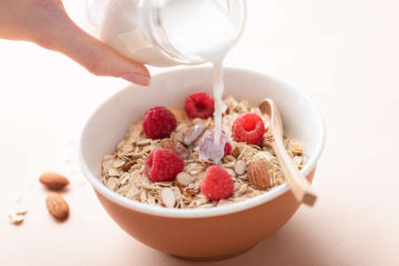 Pouring milk in oat muesli
