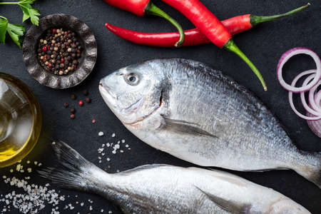Dorado fish on black slate ready for cookingの写真素材