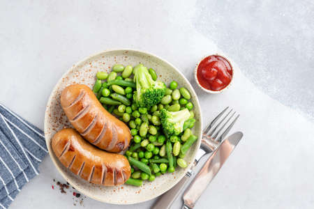 Low fat Turkey sausages served with green peas, broccoli and beansの写真素材