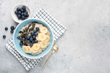 Oatmeal porridge bowl with fruits and seedsの写真素材