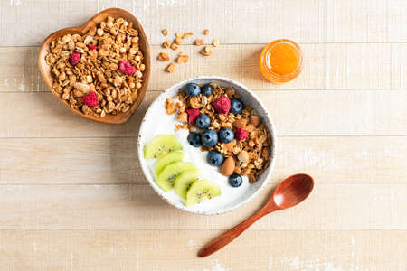 Bowl of crunchy honey granola with blueberries, kiwi and greek yogurtの写真素材