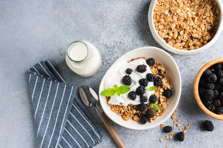 Granola and yogurt bowl with blackberries. Healthy fitness vegetarian breakfast meal, closeup viewの写真素材