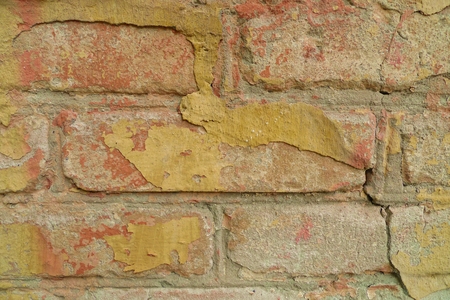 Old yellow paint on a brick wall