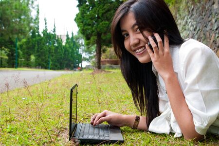 a female student relaxing in university's parkの写真素材