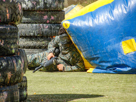 Stocking behind the trench alone, away from opponents bullets in the paintball "Tehran, Iran - August 7, 2013"のeditorial素材