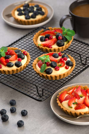 Mix berry tart, pie, with raspberries, bluberries, red currant and cream. on gray stone background.の写真素材