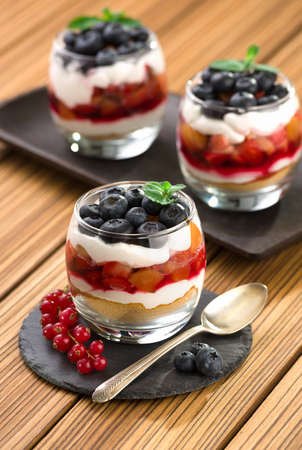 blueberry dessert, cheesecake, trifle, parfaits on wooden background.の写真素材
