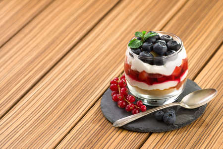 blueberry dessert, cheesecake, trifle, parfaits on wooden background. copy space.の写真素材