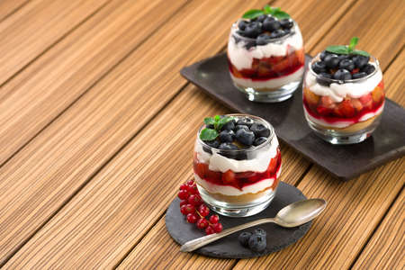 blueberry dessert, cheesecake, trifle, parfaits on wooden background. copy space.の写真素材