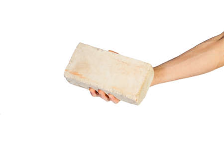 Female hand picking up white brick over white backgroundの写真素材