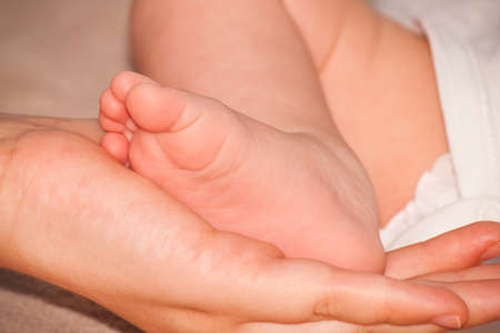 baby foot in mother's handの写真素材