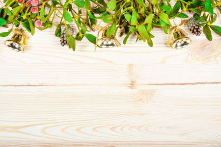 Christmas background border with gold bauble decorations, holly, mistletoe, fir and cedar cypress greenery on old parchment paper.の写真素材