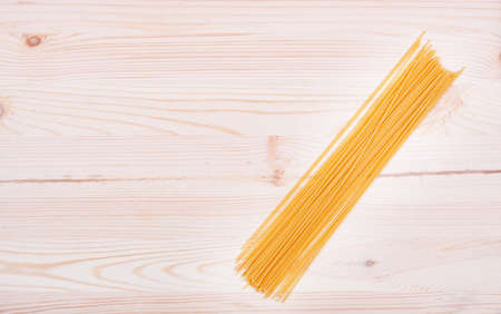 Bunch of spaghetti on wooden table background with copy spaceの写真素材
