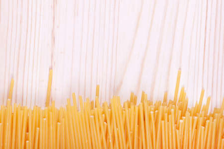 Bunch of spaghetti on wooden table background with copy spaceの写真素材