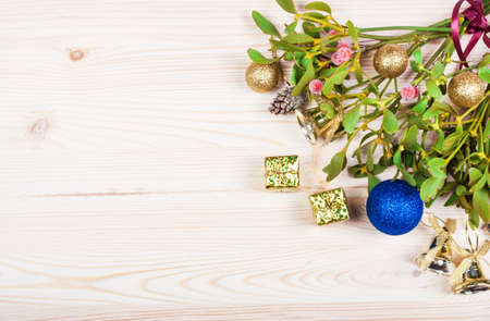 Christmas background border with gold bauble decorations, holly, mistletoe, fir and cedar cypress greenery on old parchment paper.の写真素材