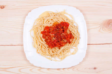 spaghetti and tomato sauce on wooden tableの写真素材