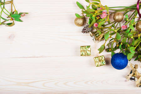 Christmas background border with gold bauble decorations, holly, mistletoe, fir and cedar cypress greenery on old parchment paper.の写真素材