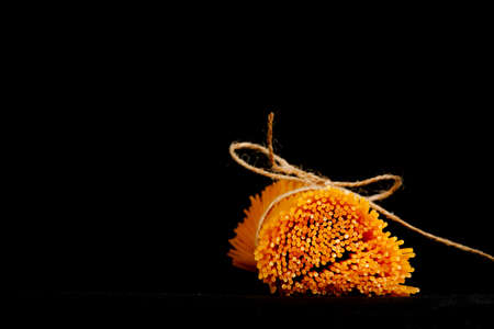Uncooked spaghetti isolated on black backgroundの写真素材