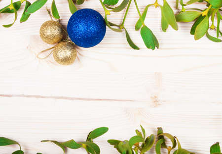 Christmas background border with gold bauble decorations, holly, mistletoe, fir and cedar cypress greenery on old parchment paper.の写真素材