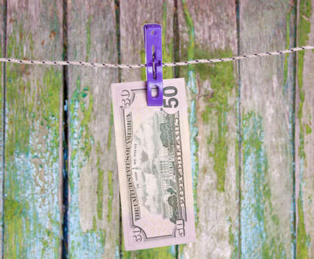 Dollar bills hanging on rope attached with clothes pins. Money-laundering concept.の写真素材