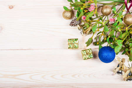 Christmas background border with gold bauble decorations, holly, mistletoe, fir and cedar cypress greenery on old parchment paper.の写真素材