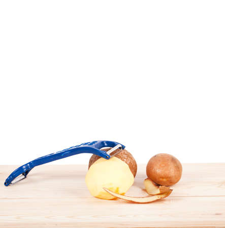 Potatoes, with a potato peeler, isolated on white backgroundの写真素材