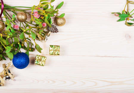 Christmas background border with gold bauble decorations, holly, mistletoe, fir and cedar cypress greenery on old parchment paper.の写真素材