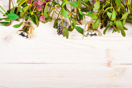 Christmas background border with gold bauble decorations, holly, mistletoe, fir and cedar cypress greenery on old parchment paper.の写真素材