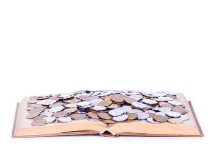A big open book with coins. Isolated on white.の写真素材