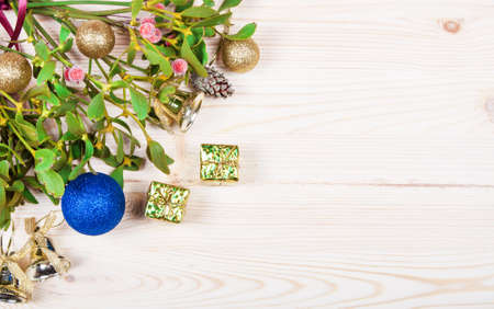 Christmas background border with gold bauble decorations, holly, mistletoe, fir and cedar cypress greenery on old parchment paper.の写真素材