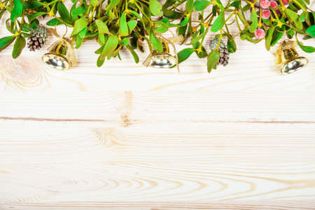 Christmas background border with gold bauble decorations, holly, mistletoe, fir and cedar cypress greenery on old parchment paper.の写真素材