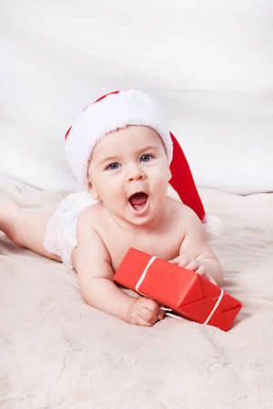Beautiful little baby celebrates Christmas. New Year's holidays. Baby in Santa hatの写真素材