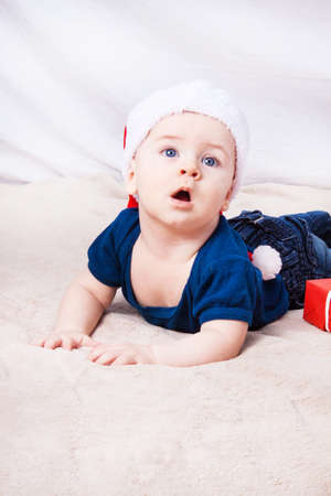 Beautiful little baby celebrates Christmas. New Year's holidays. Baby in Santa hatの写真素材