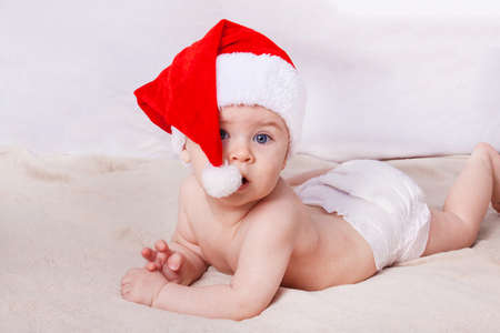 Beautiful little baby celebrates Christmas. New Year's holidays. Baby in Santa hatの写真素材